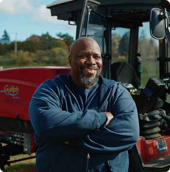 A man standing in front of an industrial lawn mower
