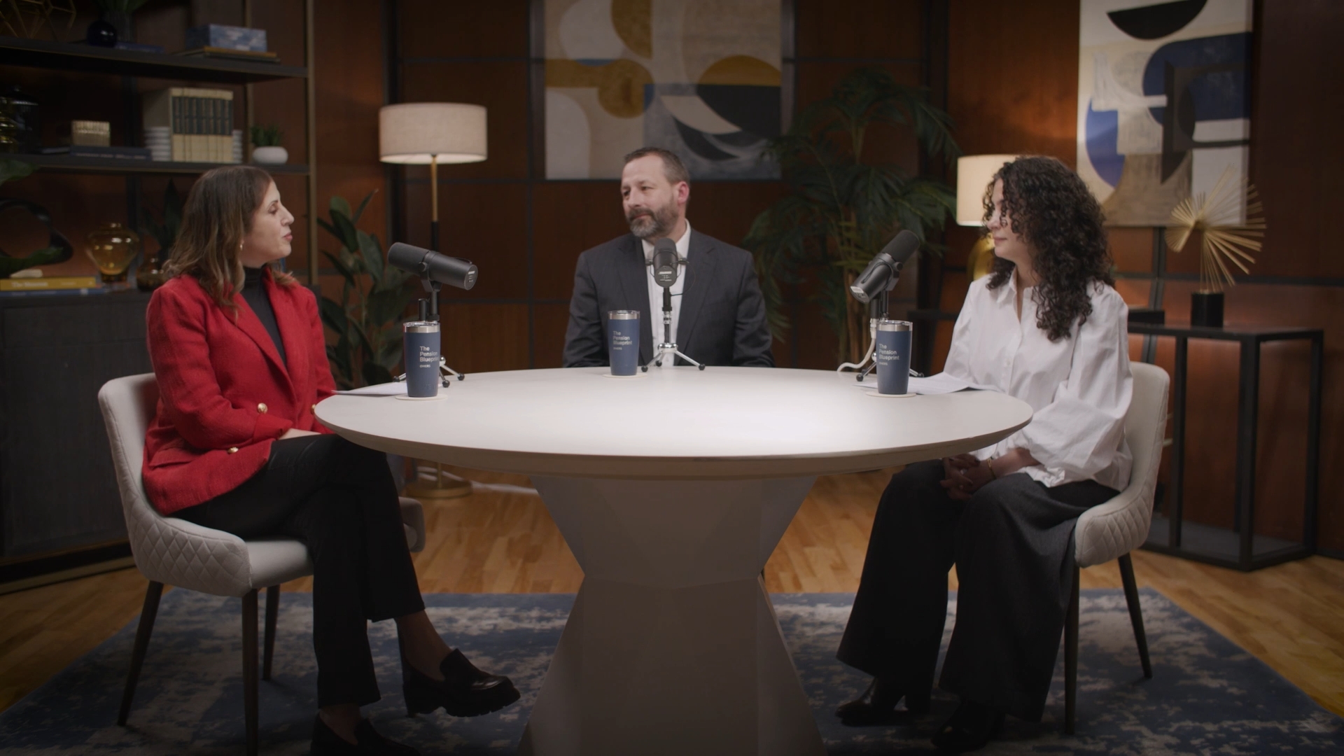 Three people sitting at a table with microphones