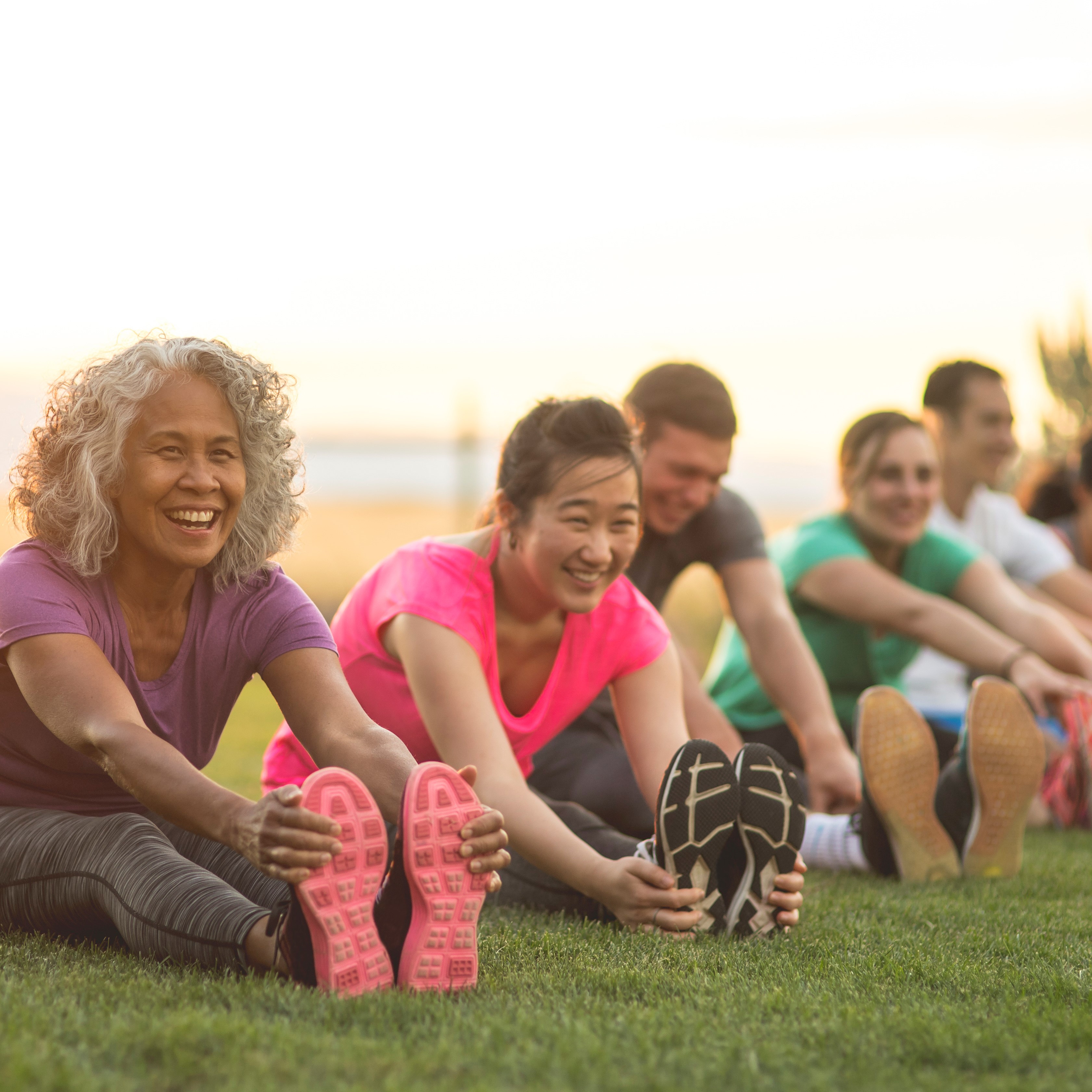 A group of people outside stretching on the grass