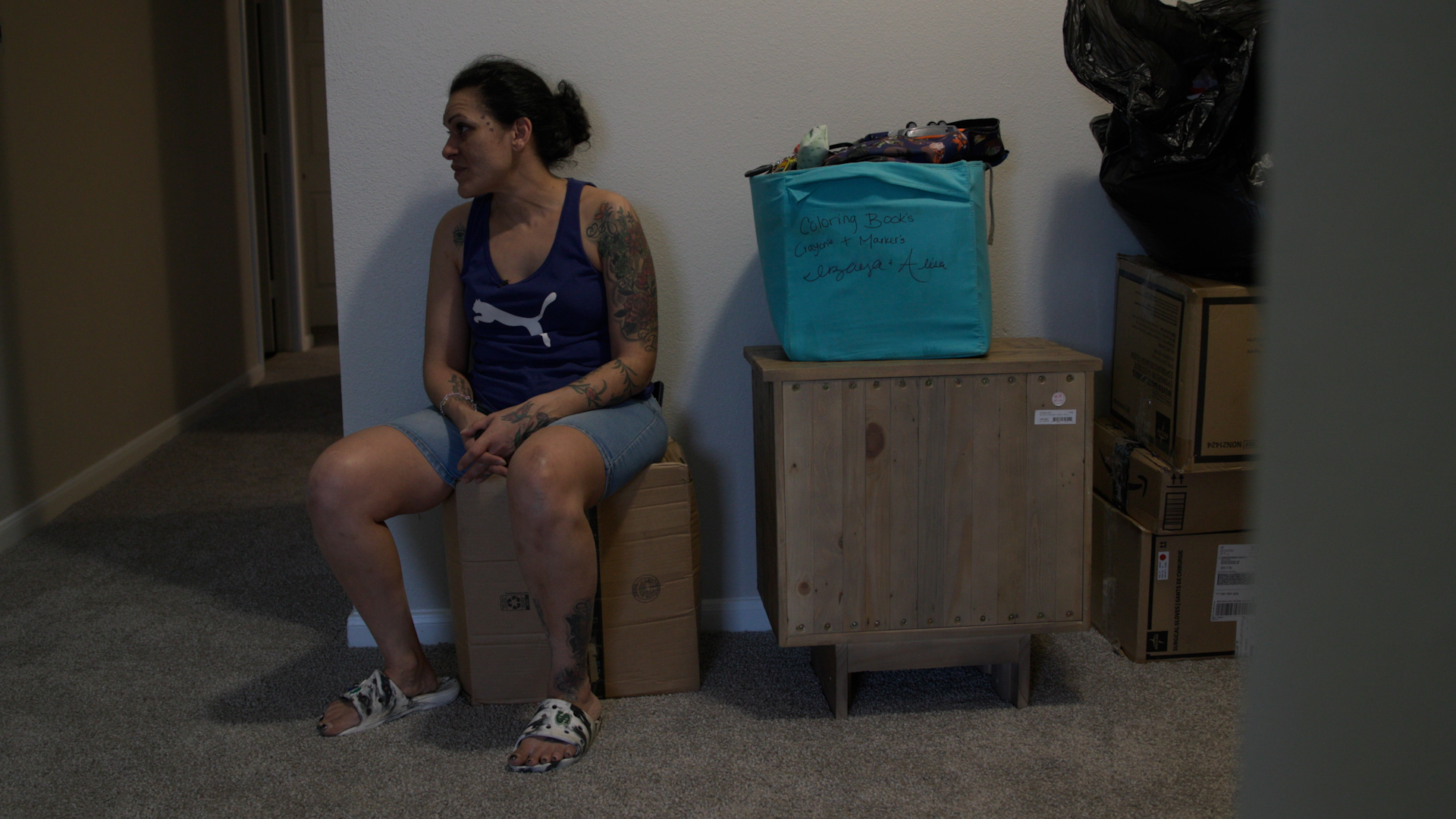 Vasquez sits on a box in her new apartment. If she had not been able to find a new home in time, she would have lost her voucher. “My mental health was very–it was tested,” Vasquez says. “It was tested.”