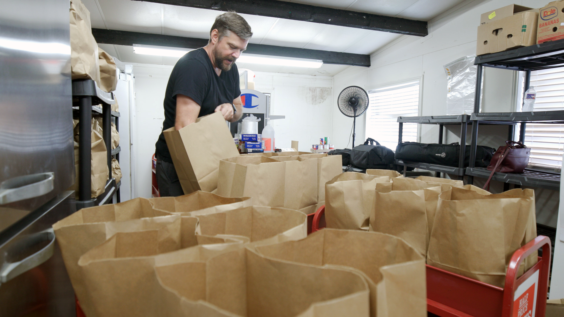 Impact Now Dove Springs executive director David Horning prepares bags for packing food. Horning says they are now serving hundreds of families weekly.