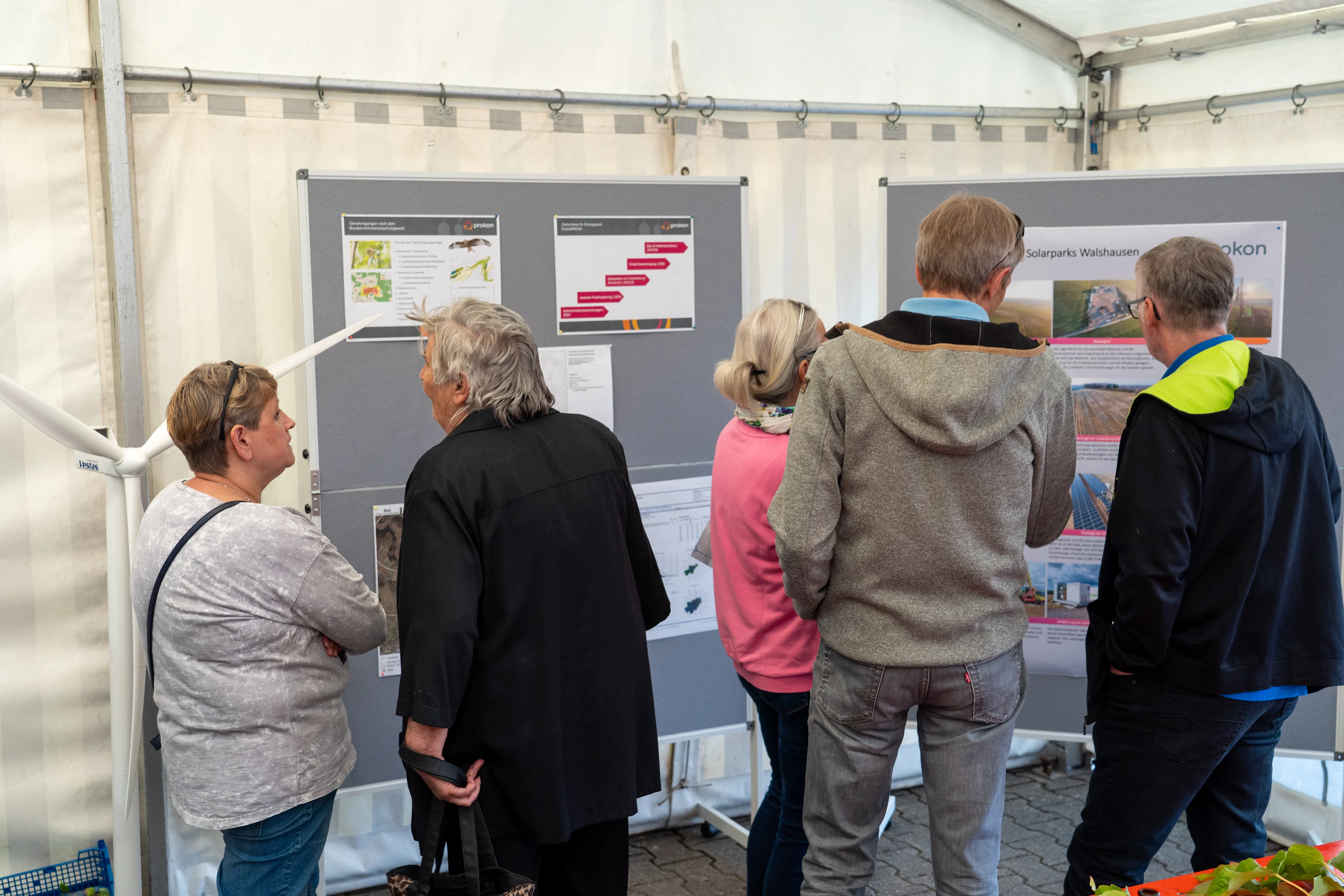 Citizens at an information event in front of notice boards with information about planned projects of Prokon eG