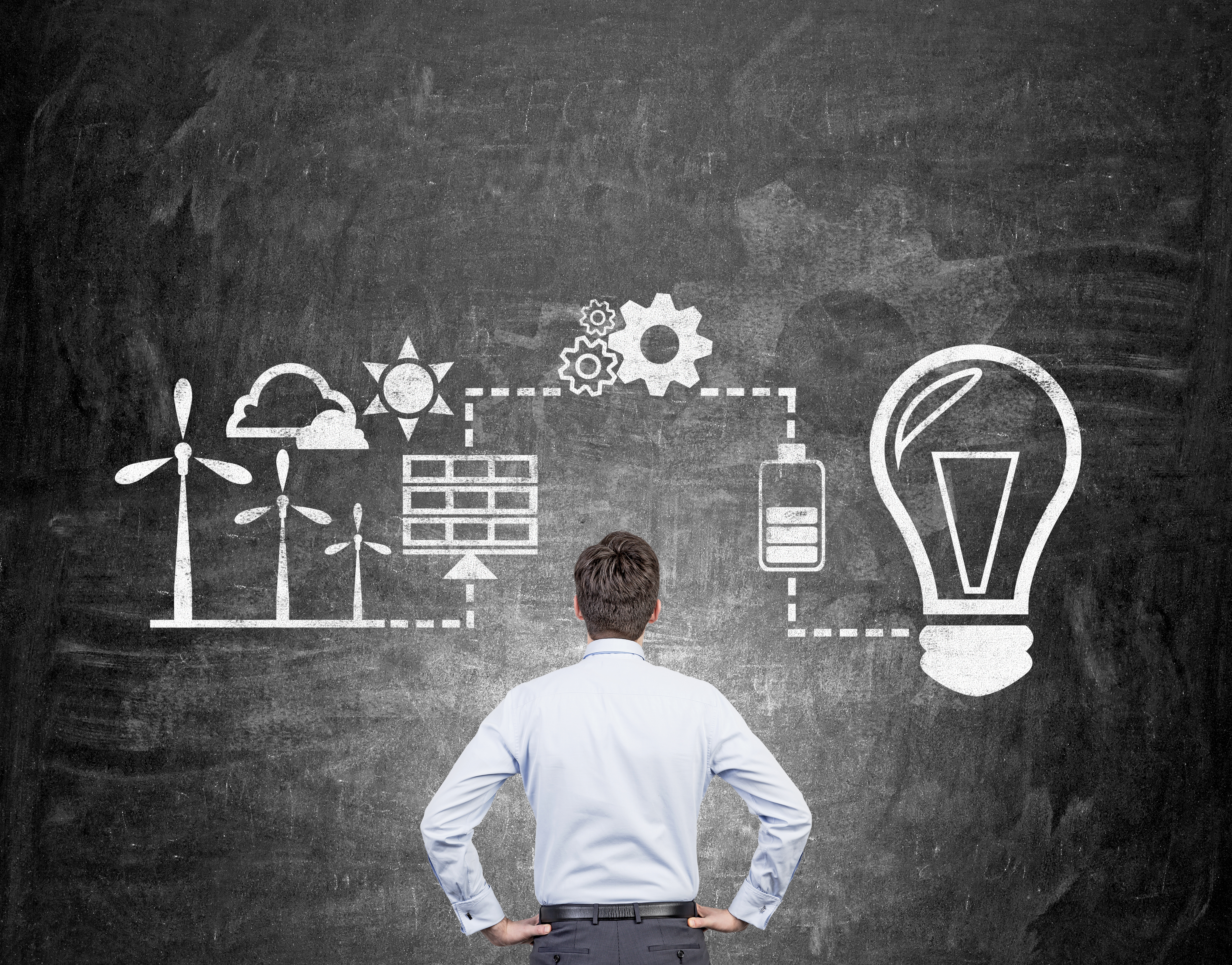 Ein Mann sieht sich auf einer Grafik die Verbindung zwischen Wind, Sonne uns elektrischem Strom an.