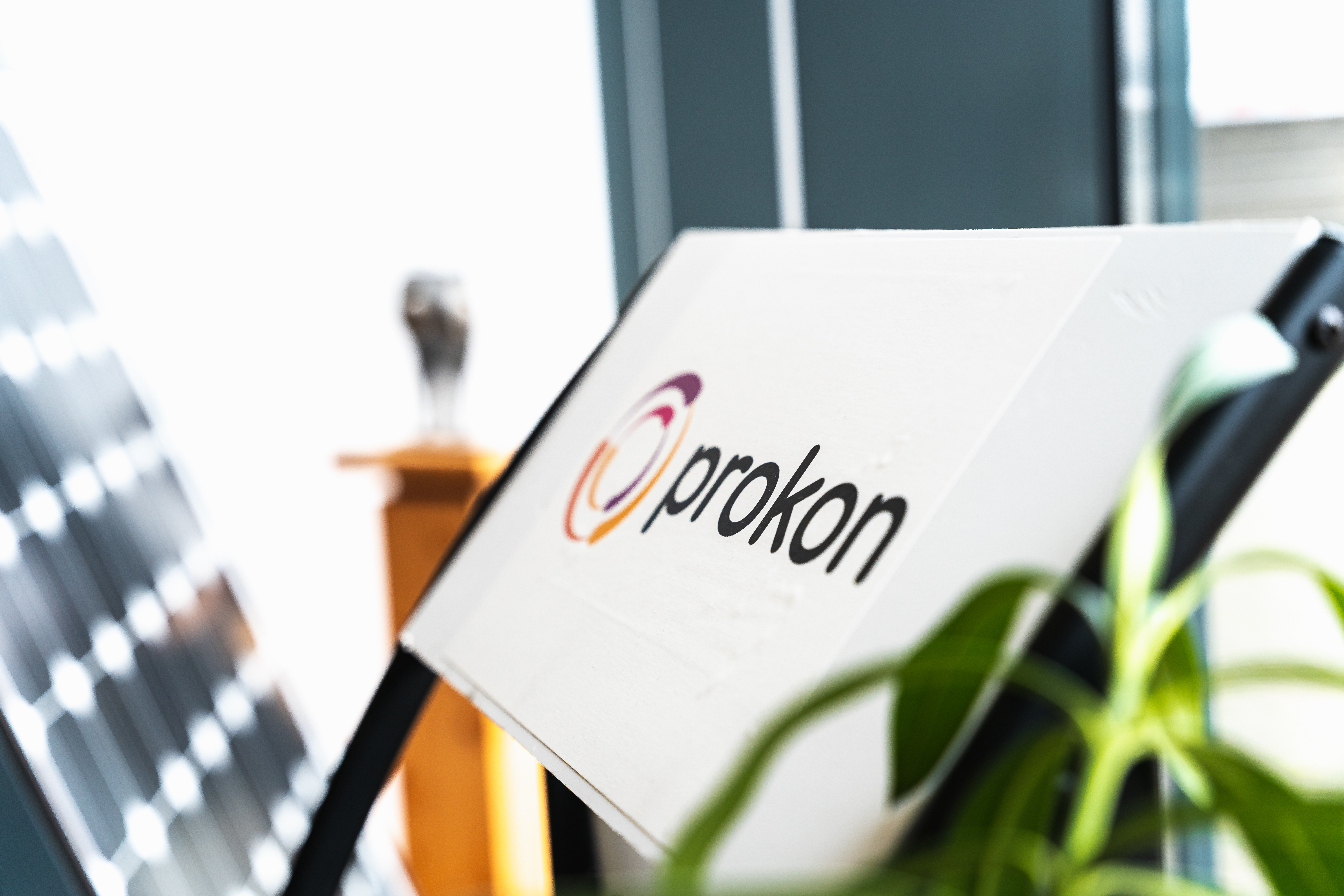 Prokon logo on a display stand with white background and black text as well as coloured rotor.