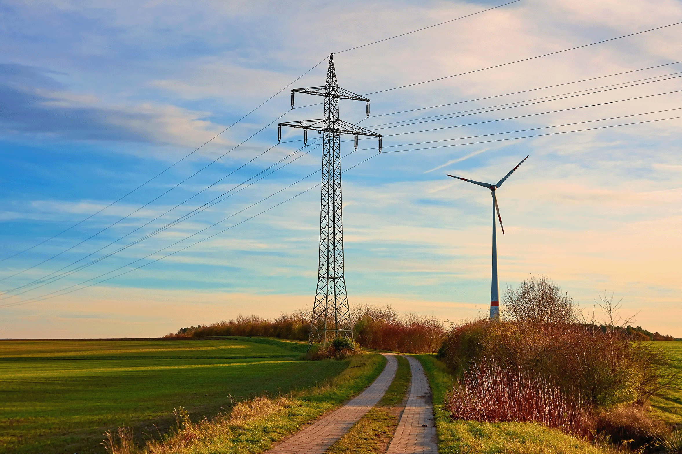 Strommast in der Nähe einer Windenergieanlage