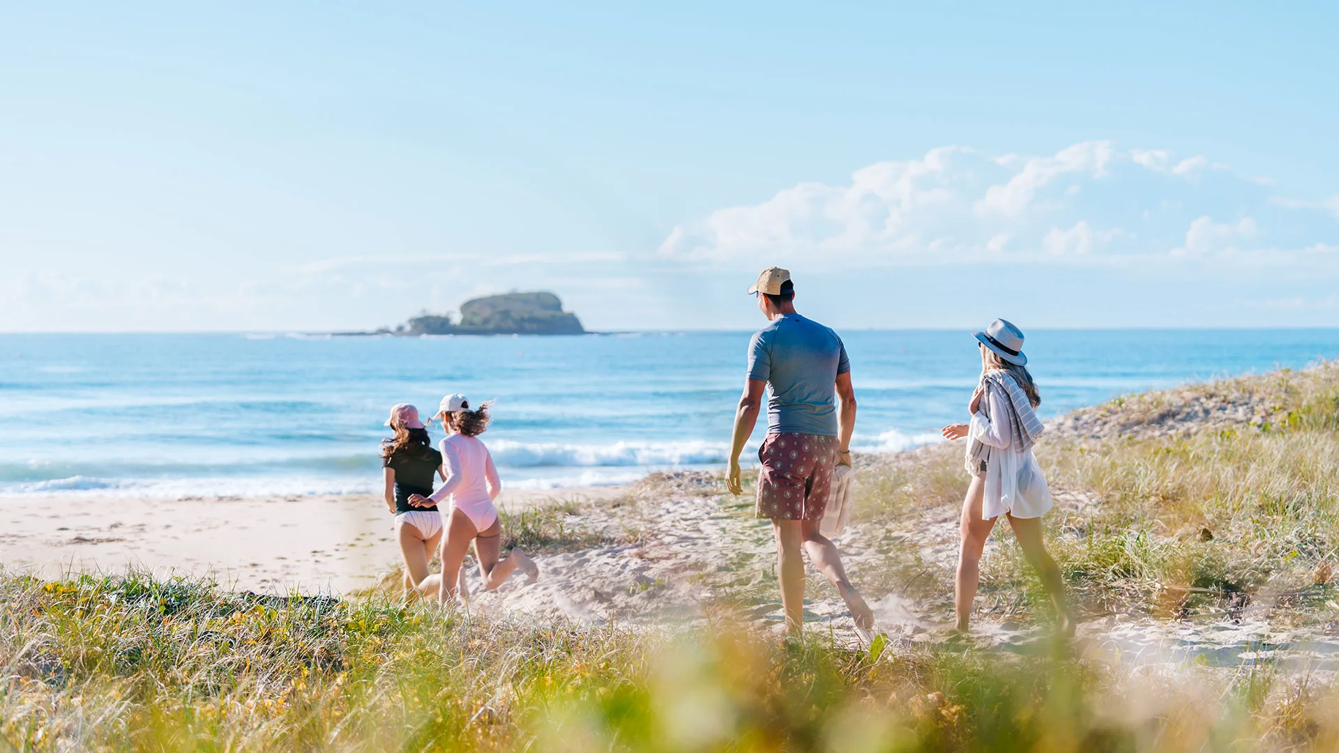 Family walking onto Mudjimba beach