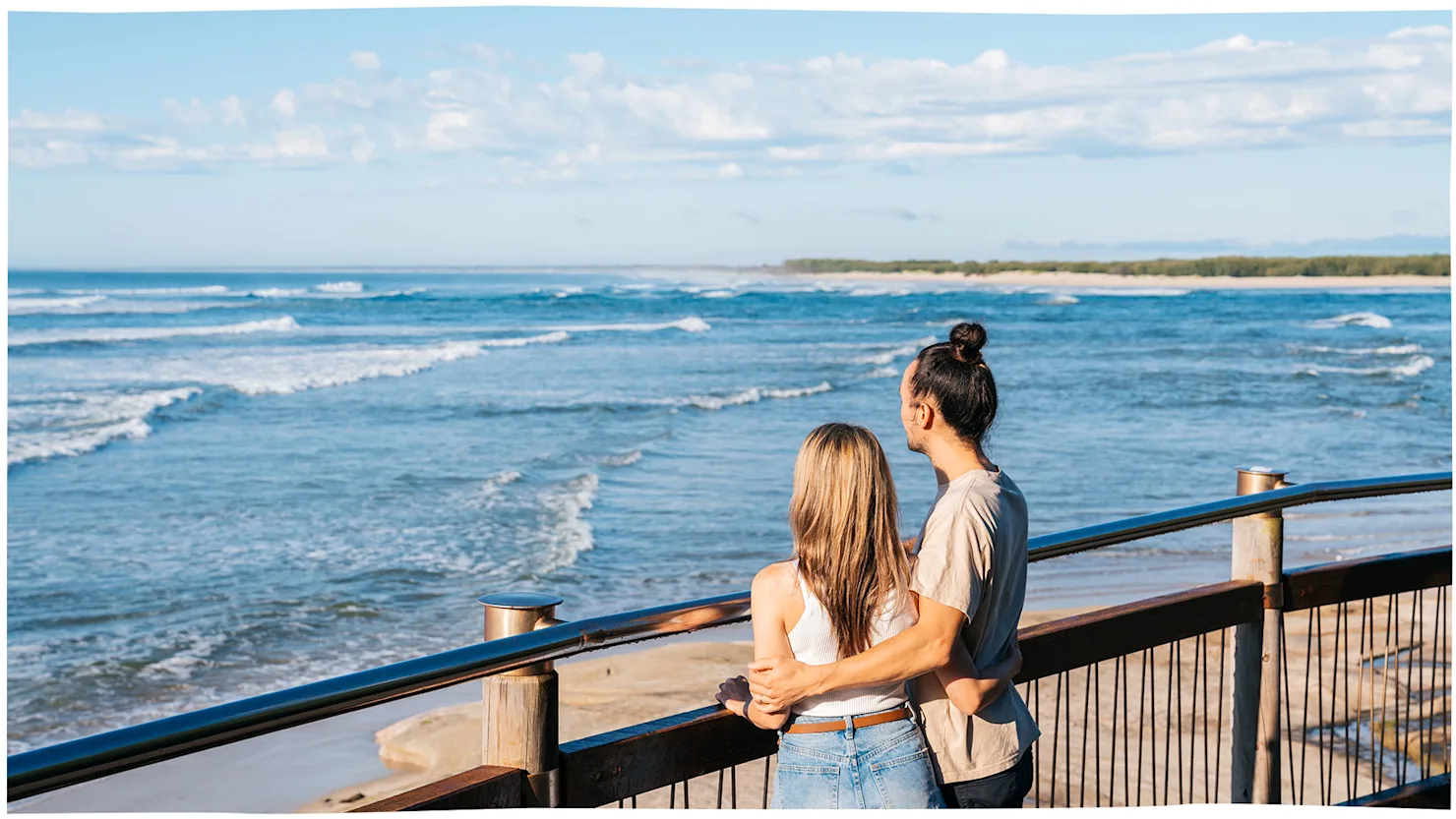 Couple walking along the boardwalk at Bulcock Beach, Caloundra