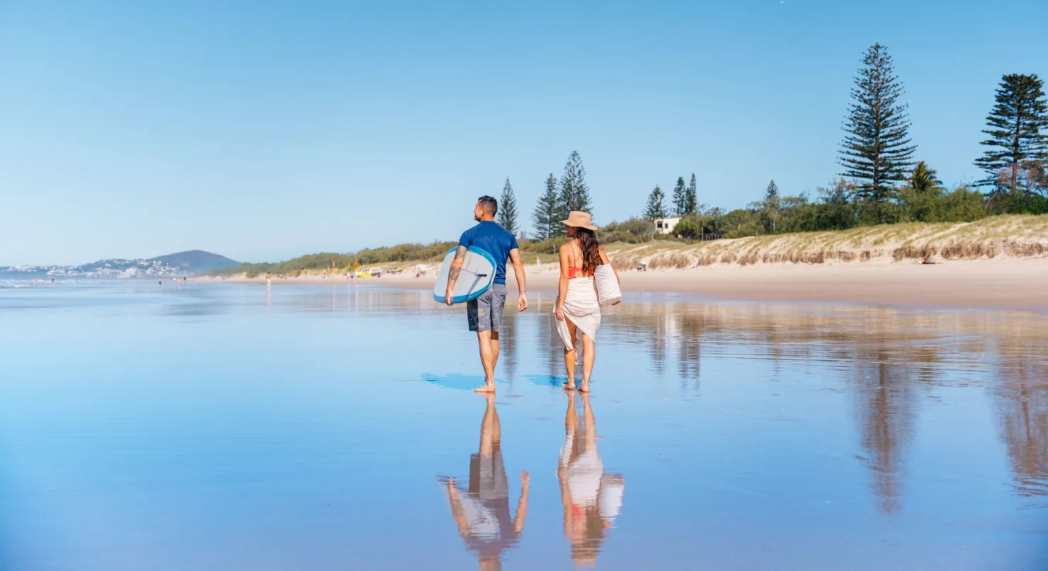 Couple walking along Peregian Beach.