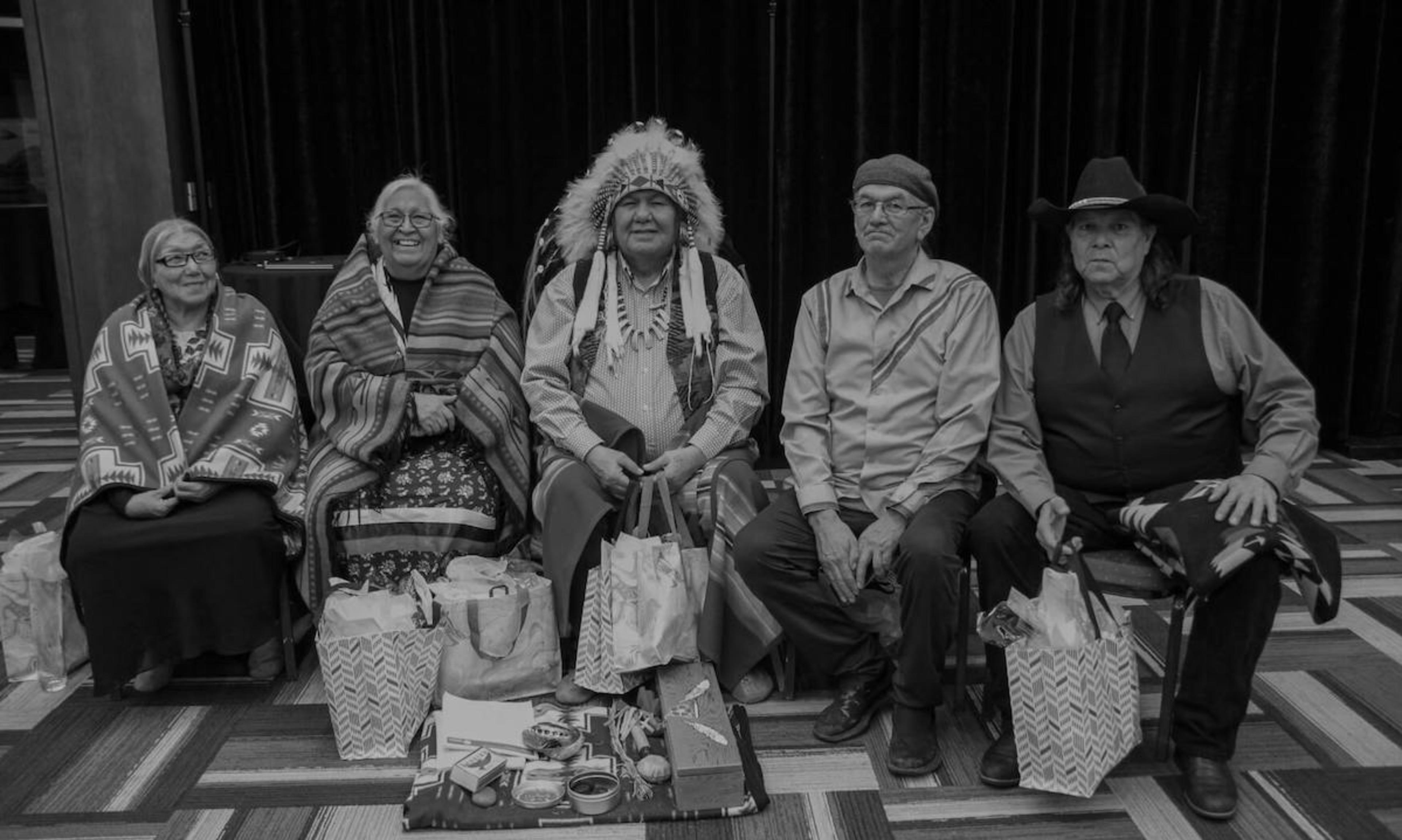 Indigenous Elders pose for a photo with shopping bags.