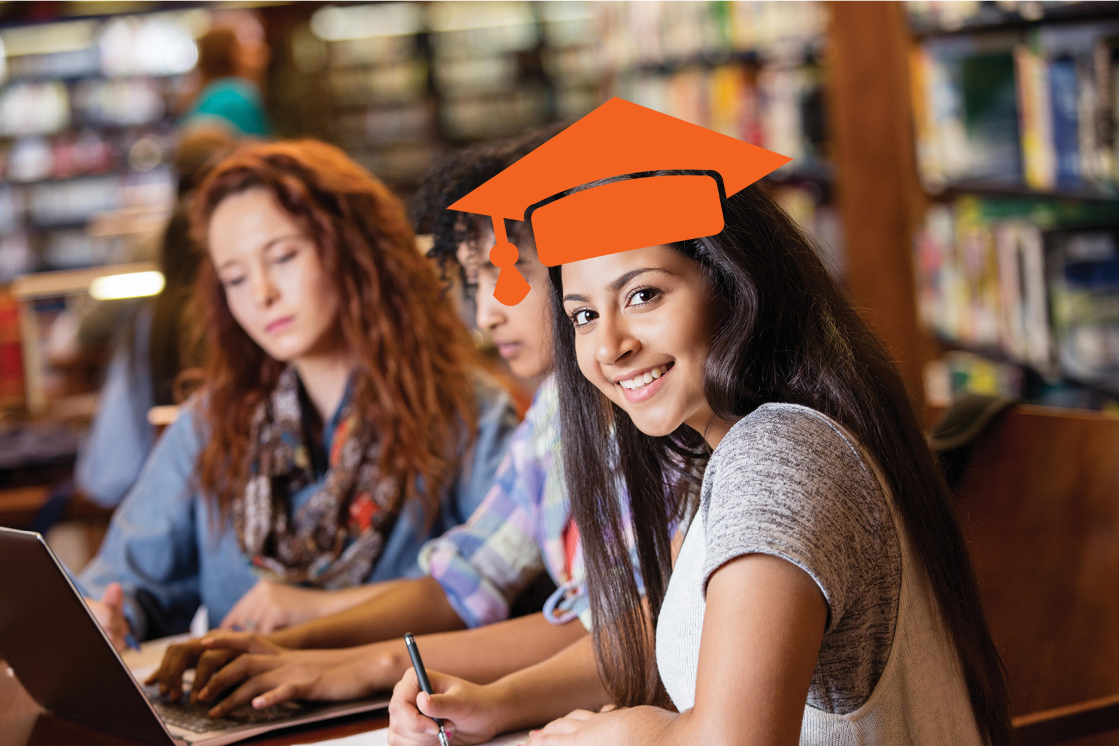 3 girls sitting at a computer, on looking forward with a graphic illustration of a mortarboard hat overlayed on her head.