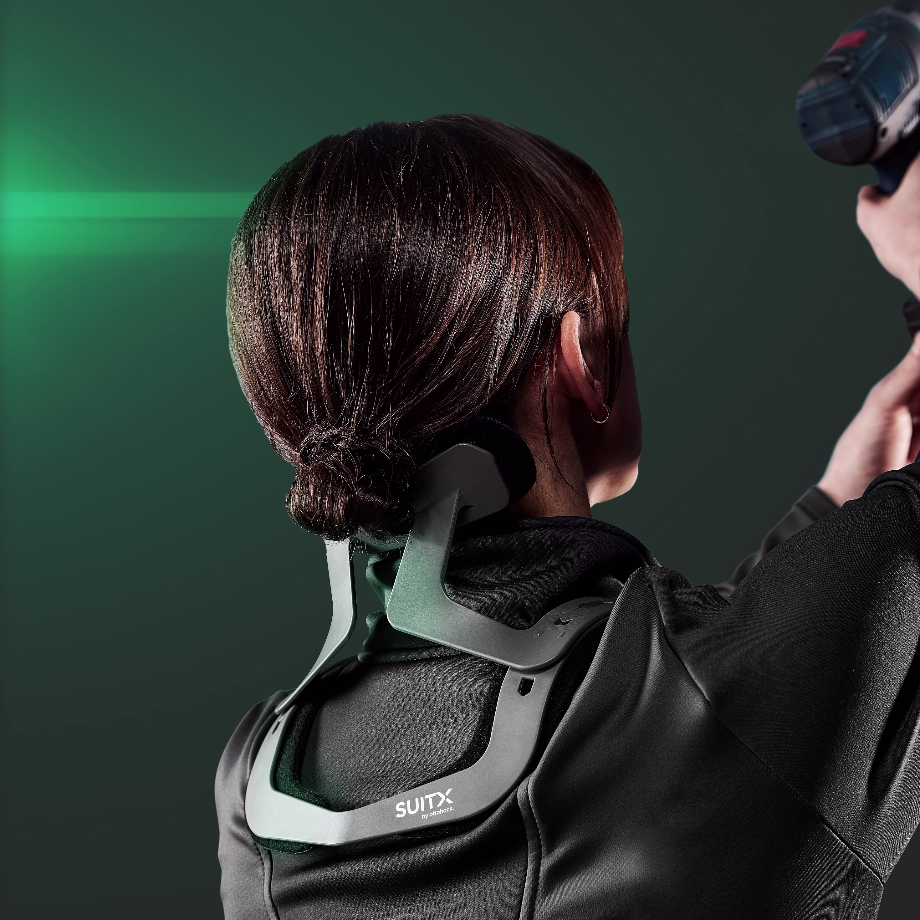 Back view of a woman using the CX Easy Neck and holding a drill in her hand