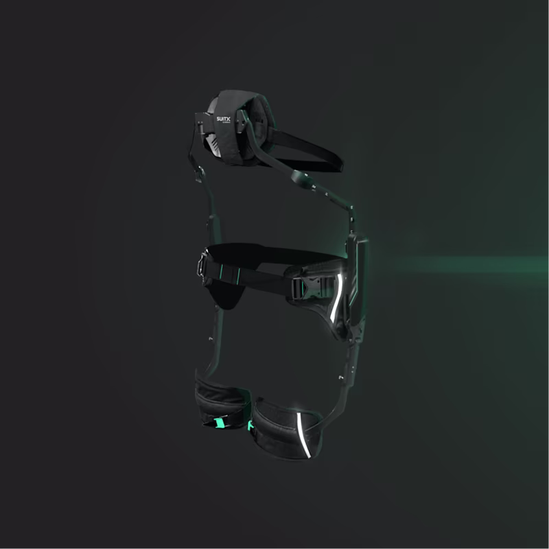 Seitenansicht des SUITX IX BACK AIR Exoskeletts vor einem dunklen Hintergrund wird von grünem Licht angestrahlt