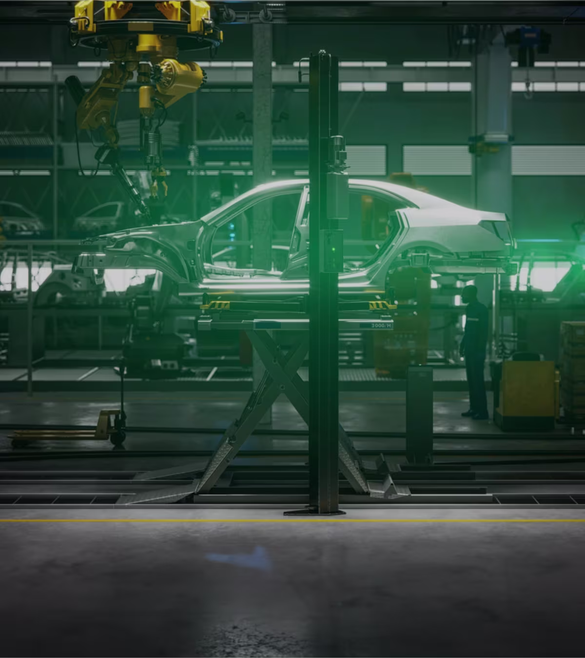 Side view of a car body on a production line in a car factory surrounded by various assembly machines