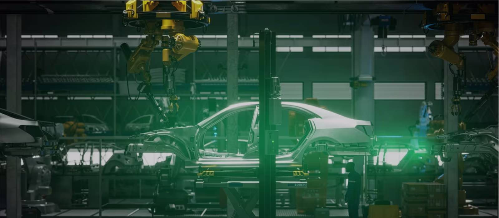 Side view of a car body on a production line in a car factory surrounded by various assembly machines