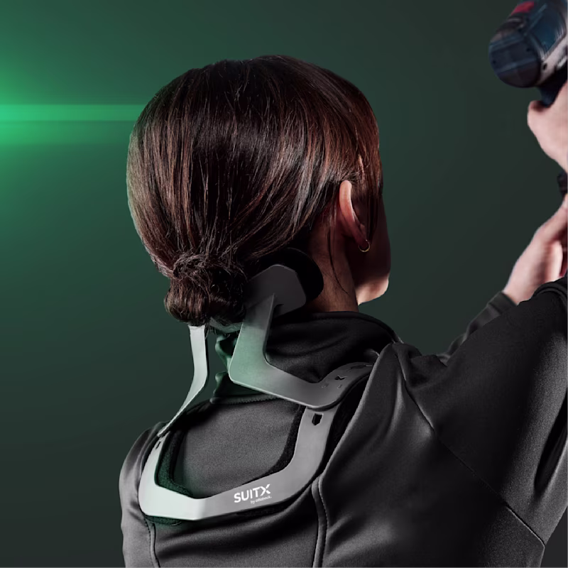 Back view of the upper body of a woman working overhead with a cordless screwdriver wearing a SUITX CX EASY NECK