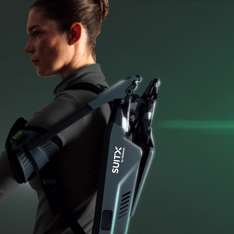 Side view of the upper body of a woman wearing a SUITX SHOULDER AIR exoskeleton and looking to the left.