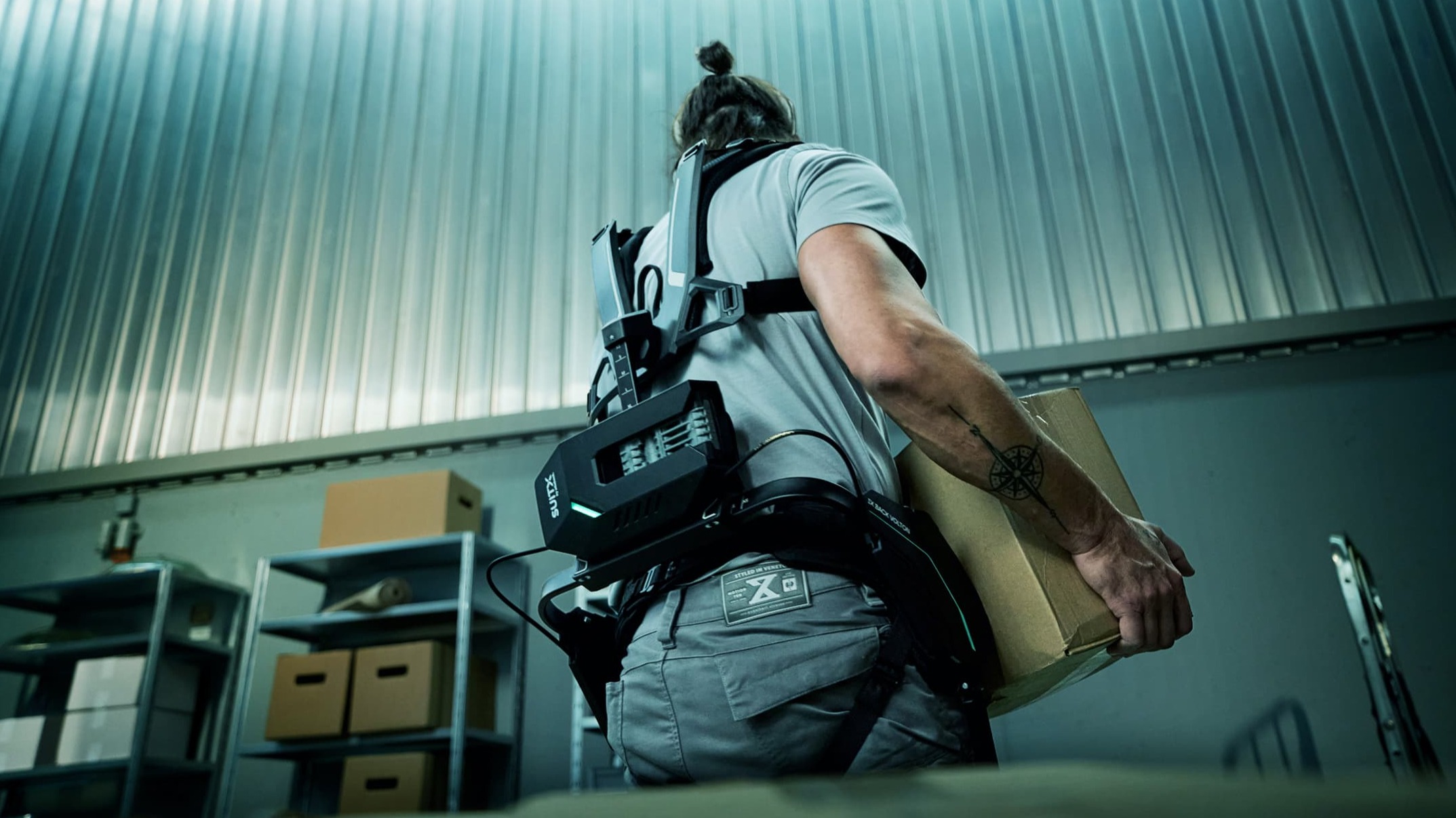 Back view of a warehouse worker wearing the IX BACK VOLTON back exoskeleton from SUITX.