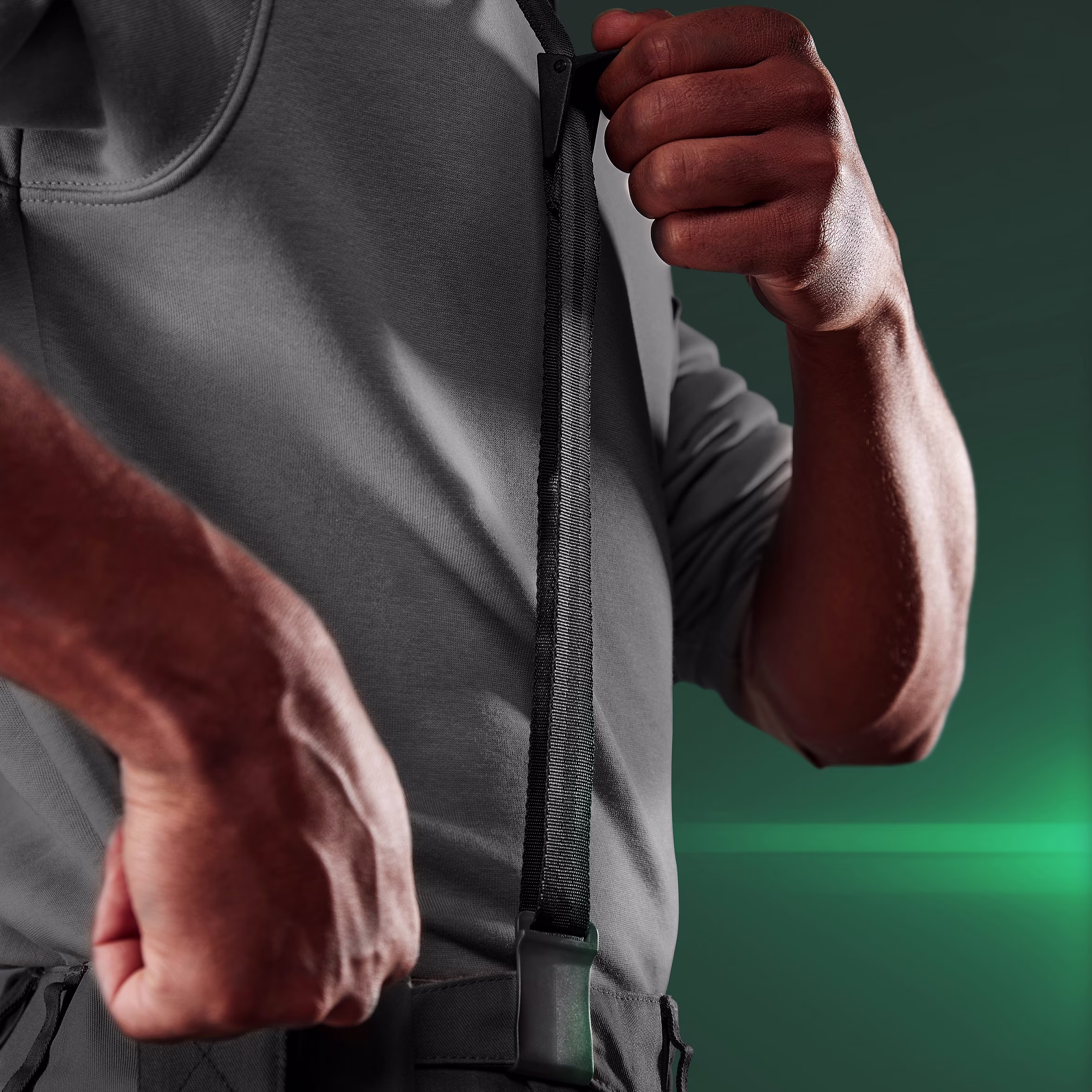 Torso view of a man attaching the straps of the CX Easy Neck to his belt