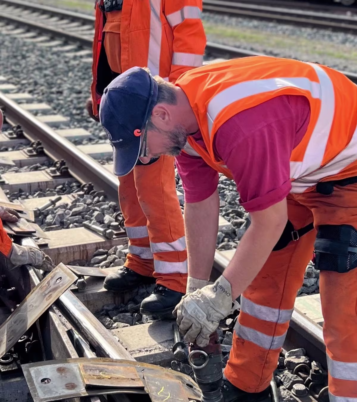 workers at train tracks in bending posture using back exoskeletons