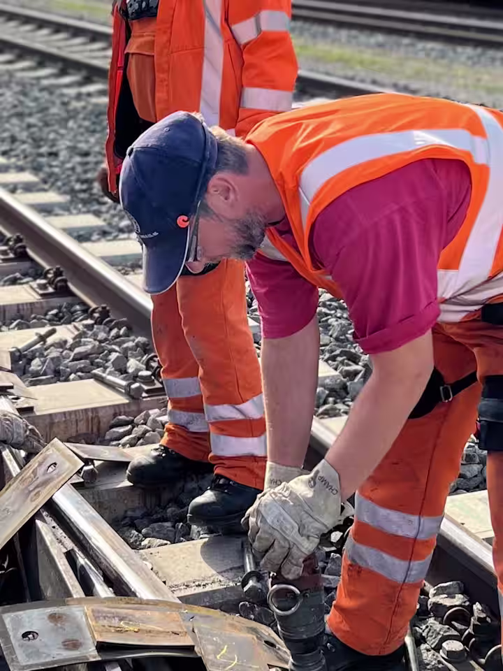 workers at train tracks in bending posture using back exoskeletons