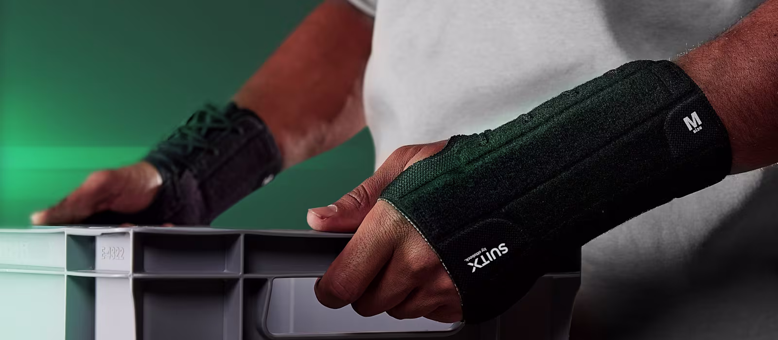 Torso view of a man carrying a box in front of his body and wearing the CX Soft Wrist.