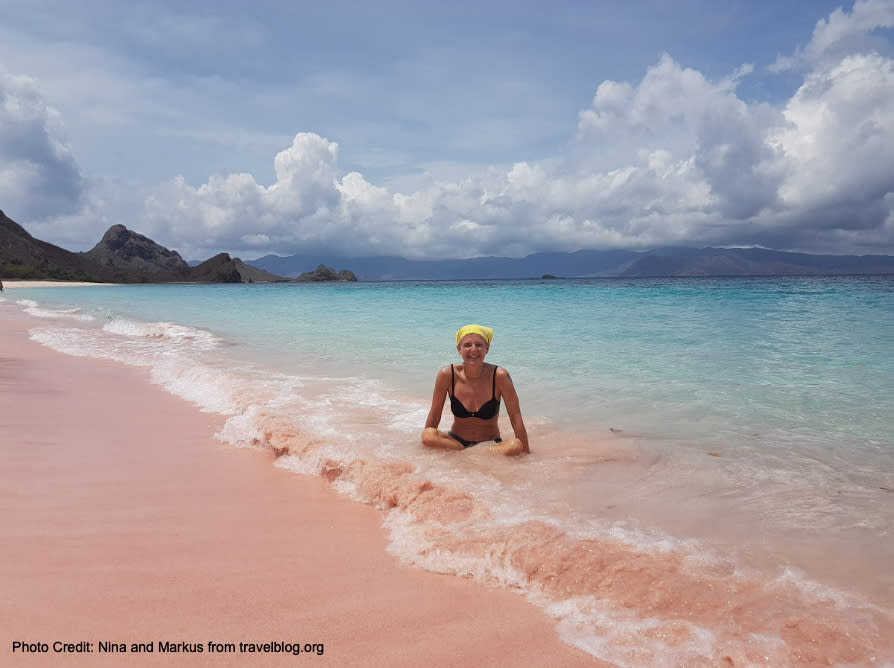 This photo from travelblog.org shows a women enjoying the more-so pink hues of the Padar Pink Beach