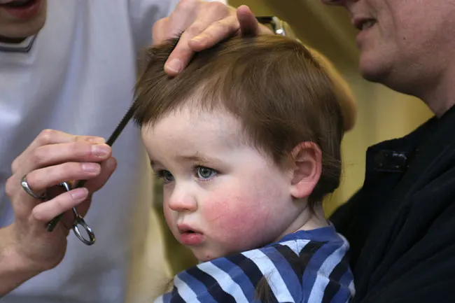 Le Coiffeur Coupe Des Cheveux D'un Garçon D'enfant Dans Le Salon