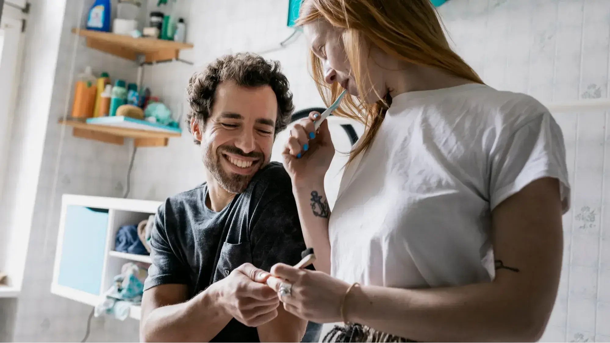A couple having a relaxed and funny moment while brushing their teeth in the bathroom