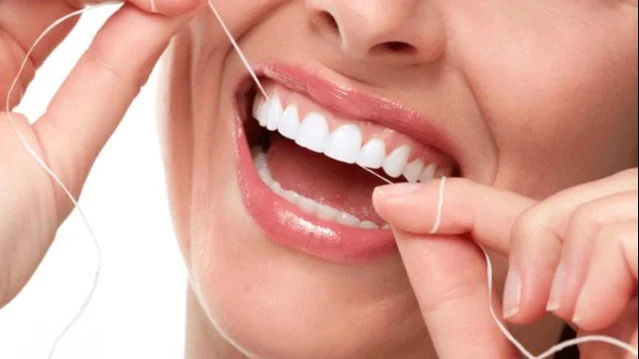 Woman flossing her teeth