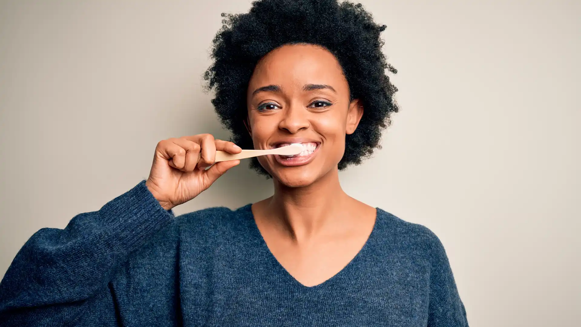 Woman smiling and brushing her teeth