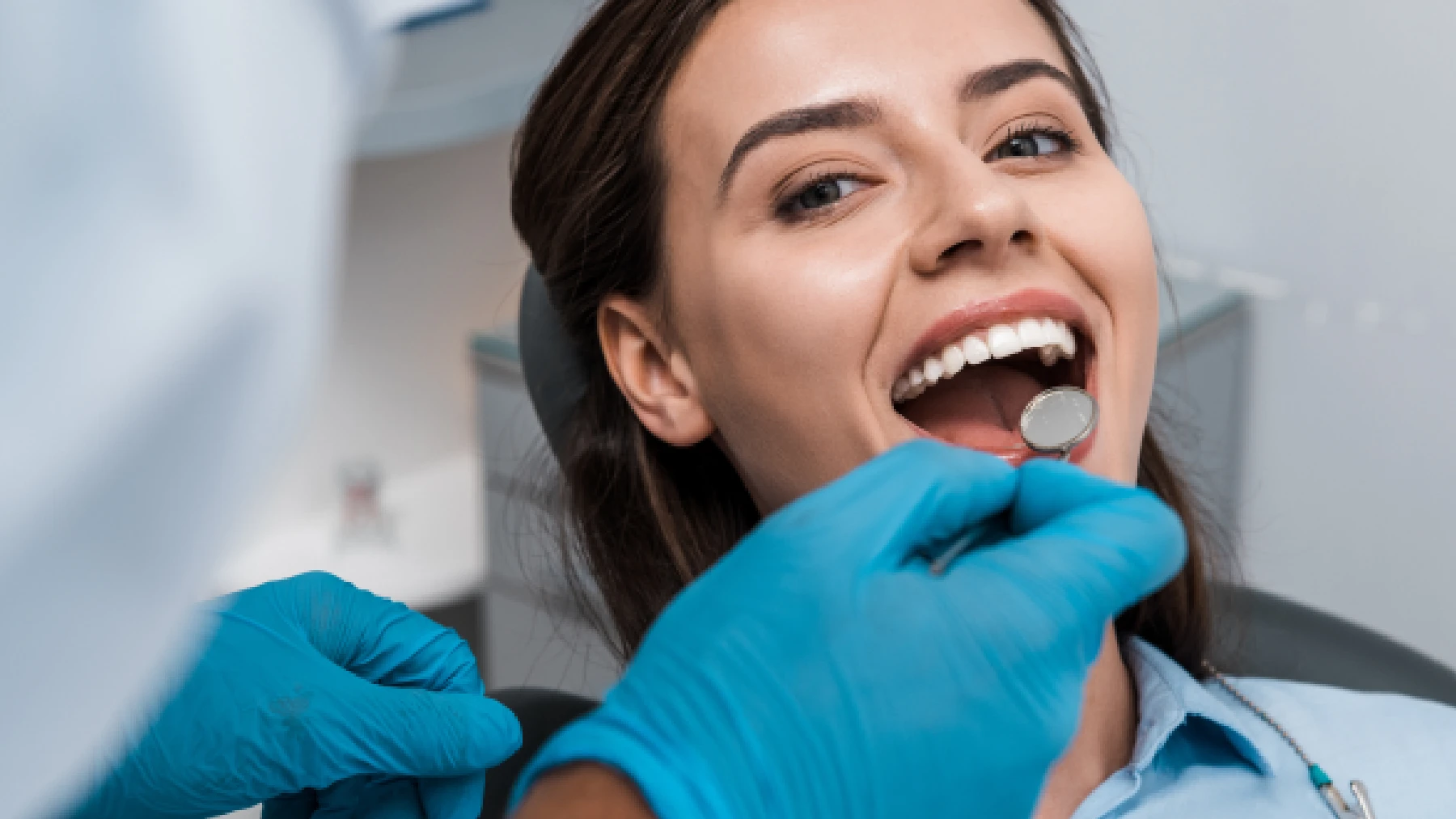 Woman smiling during a dental cleaning