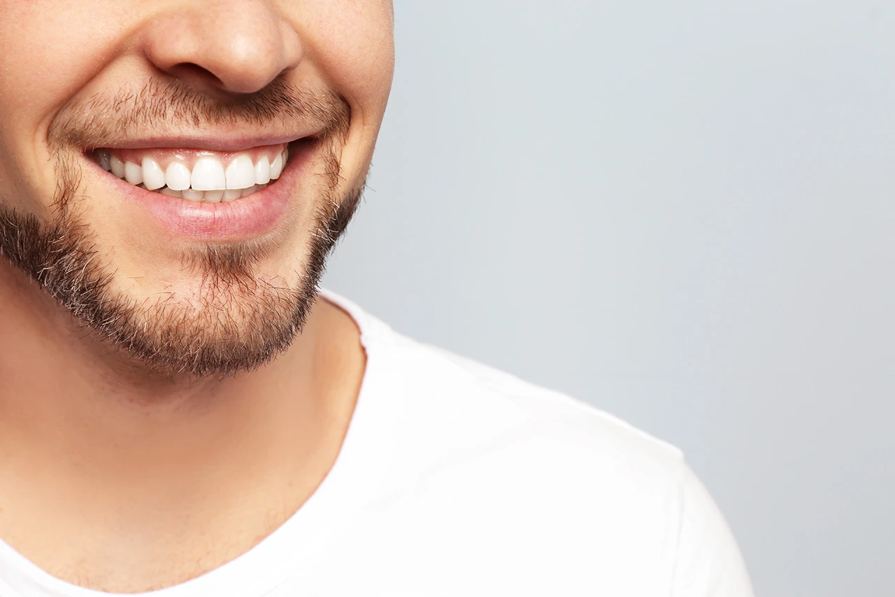A cheerful man with a bright smile, demonstrating a clean and free of plaque smile