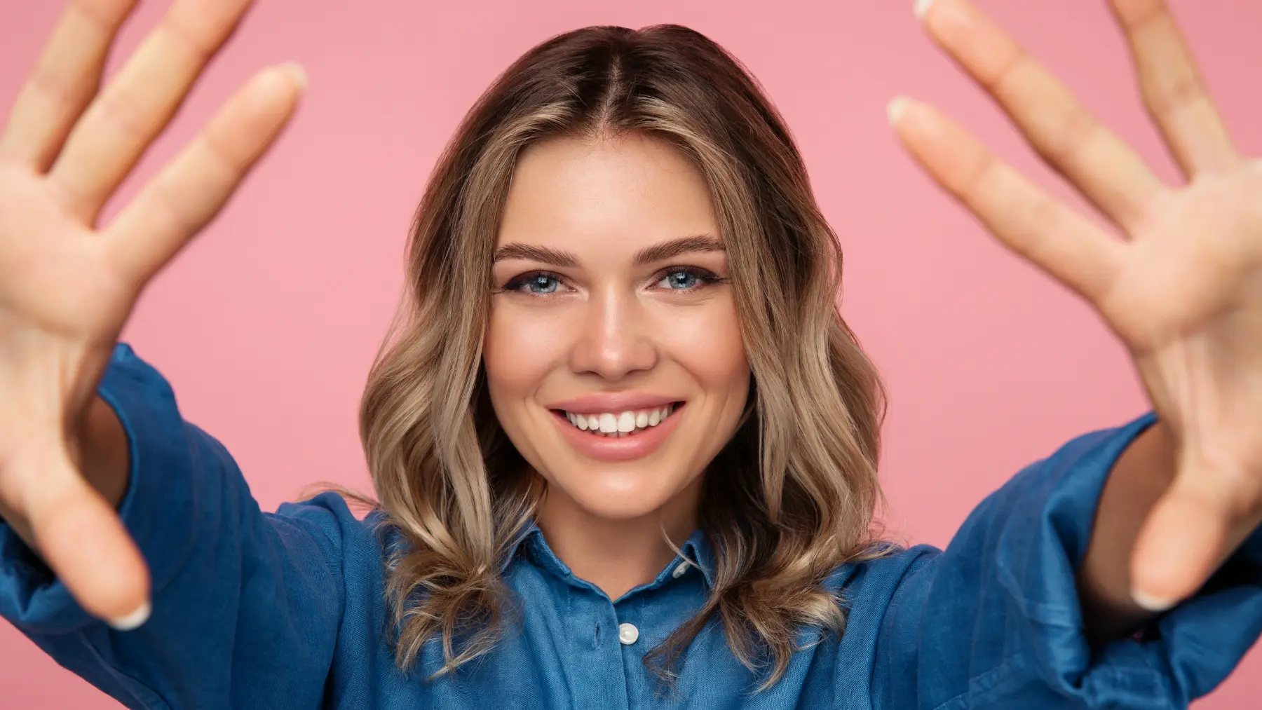 Woman with her hands up and white teeth