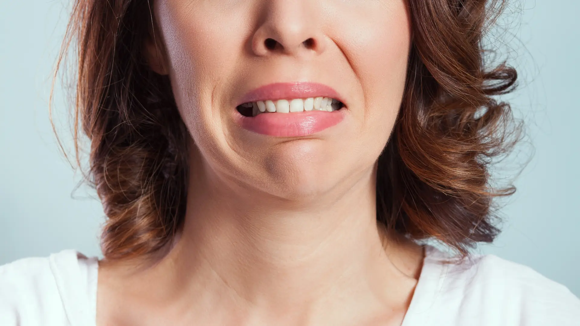 Woman grimacing with tooth pain