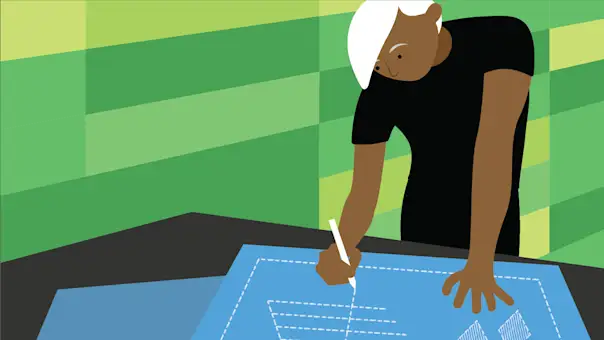 A designer stands at a conference table drawing a straight line on a blueprint.