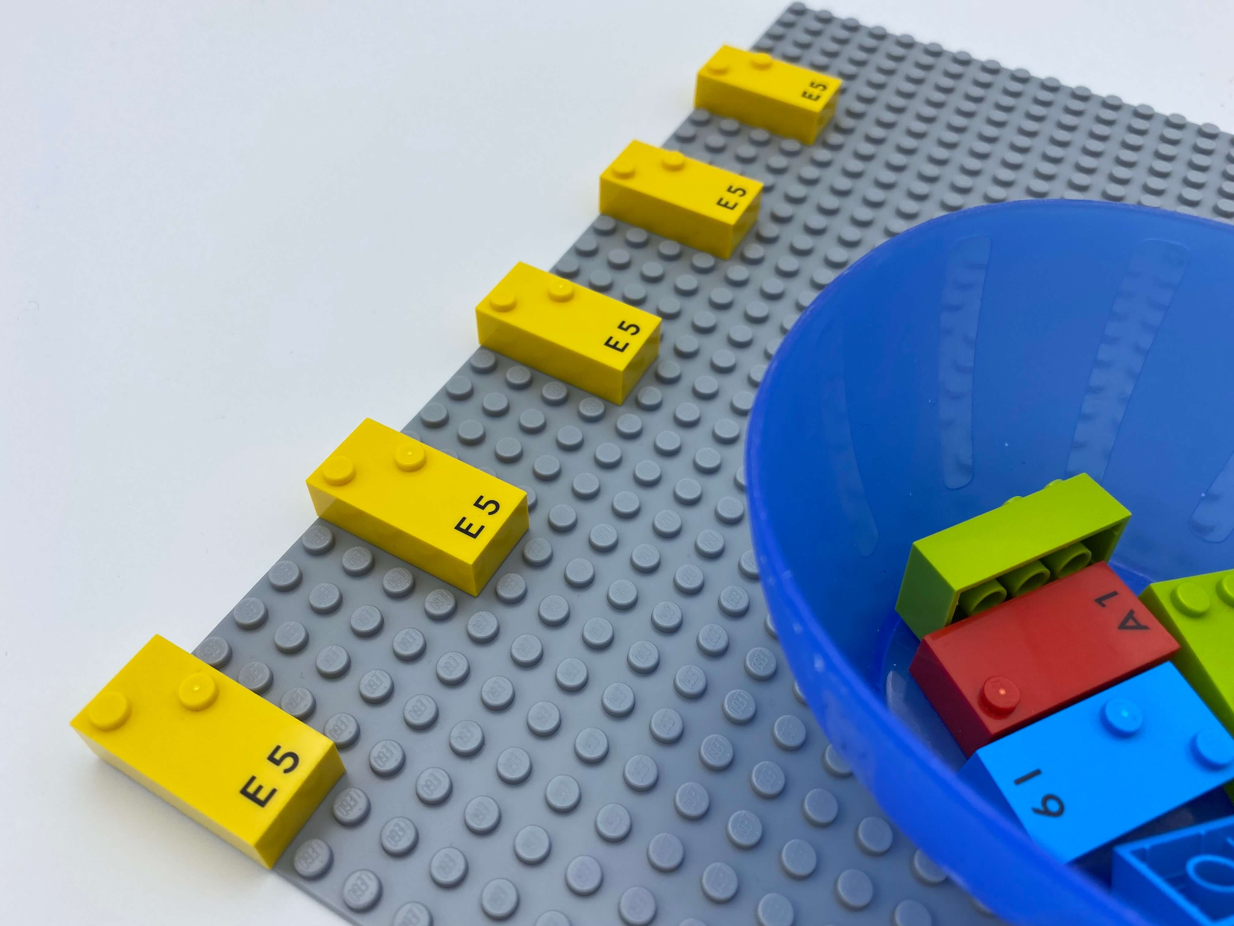 5 vertical bricks in a horizontal line on the base plate, 5 bricks in a bowl.
