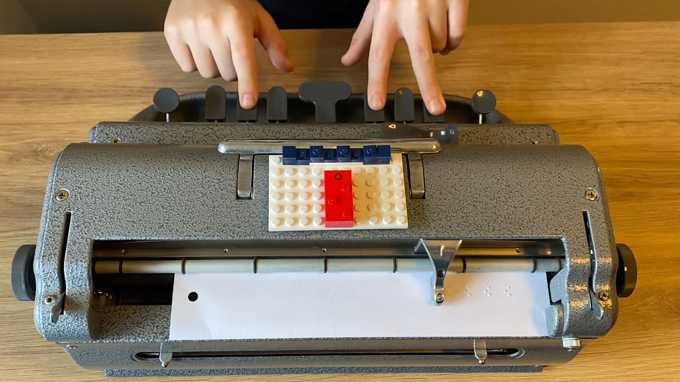 Perkins brailler used with  sample letter in LEGO Braille Bricks