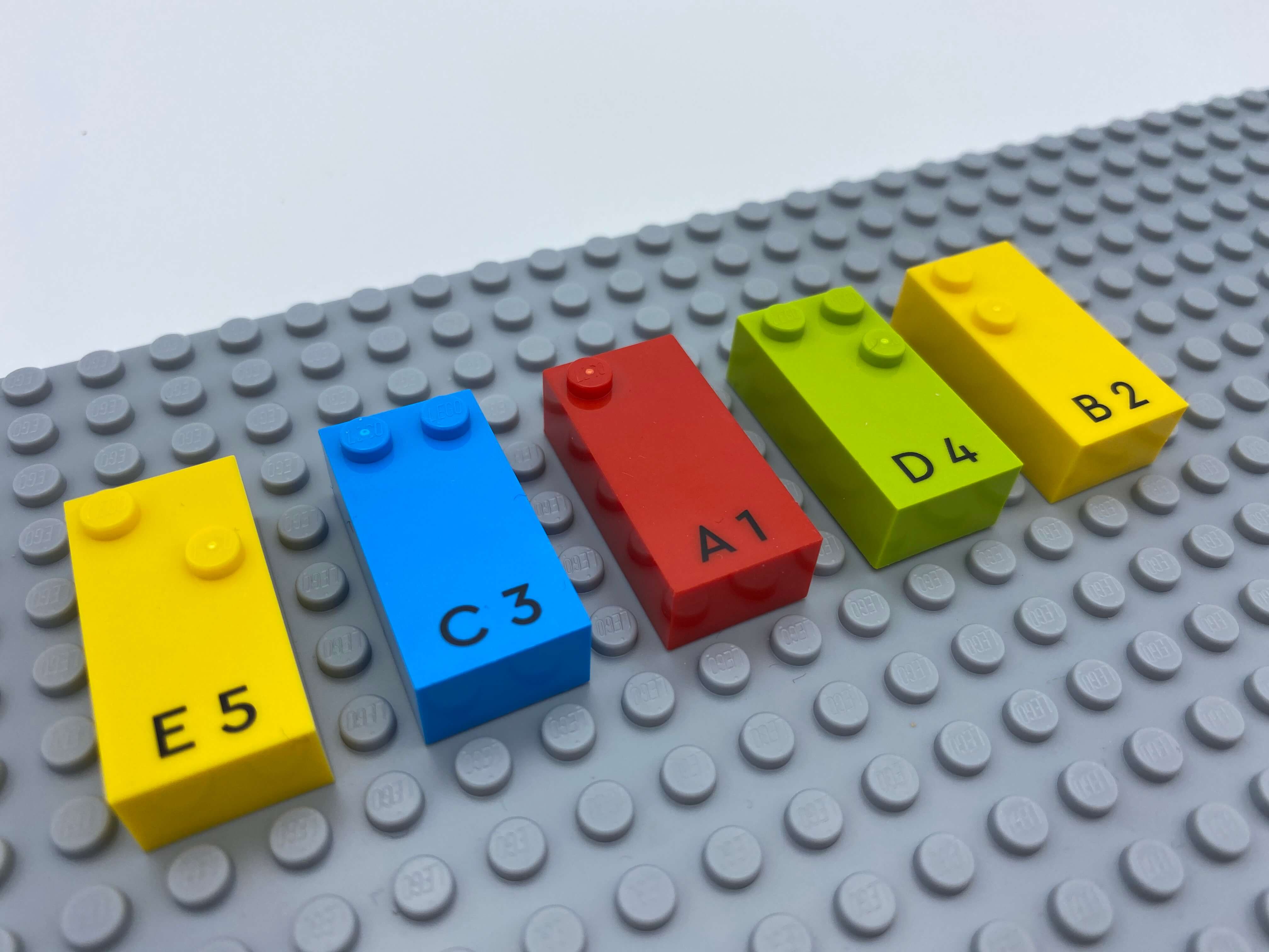5 letter bricks aligned on the base plate: e, c, a, d, b.