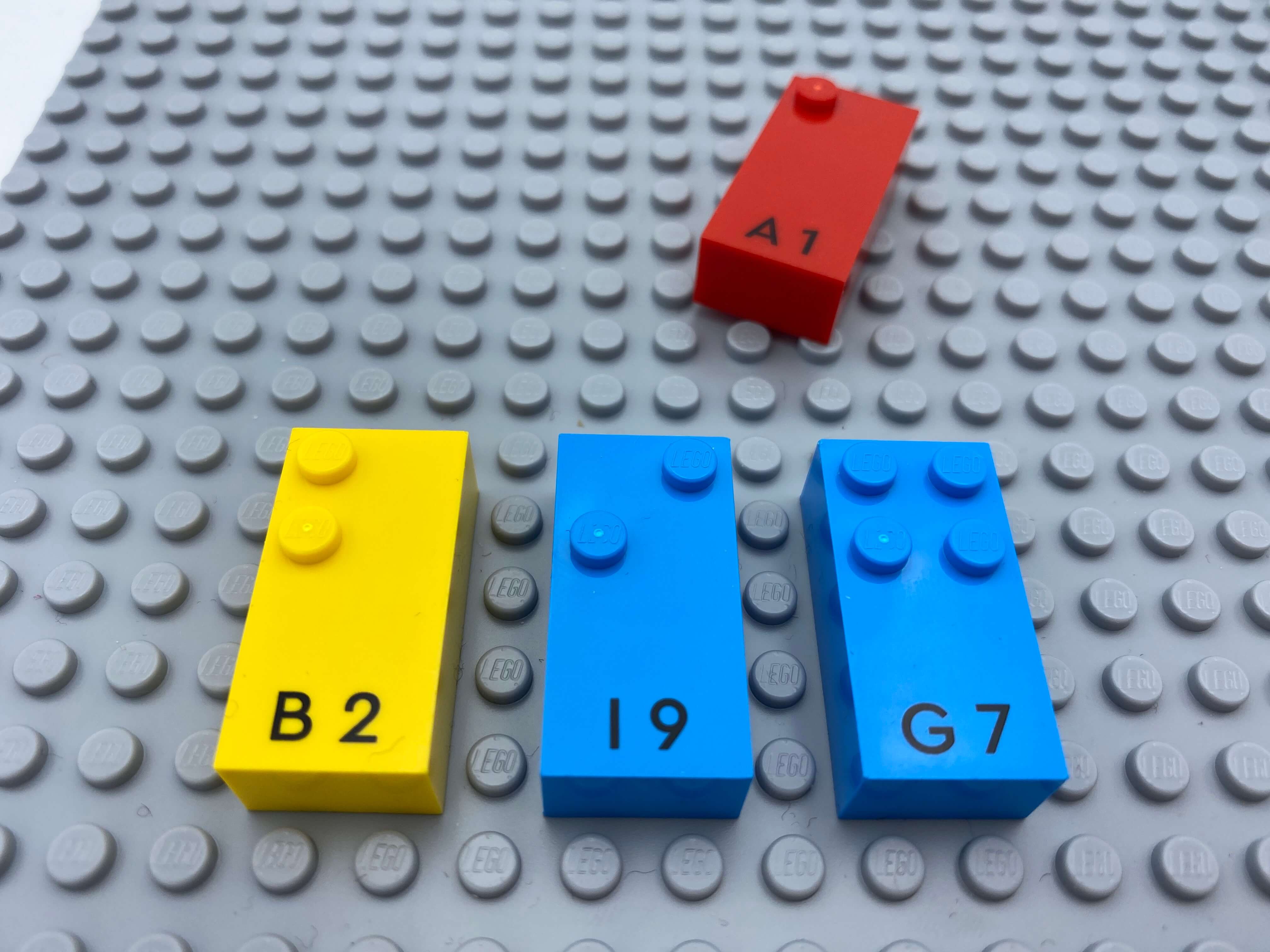 Letter bricks b, a, g aligned on the base plate, letter brick a is being added.