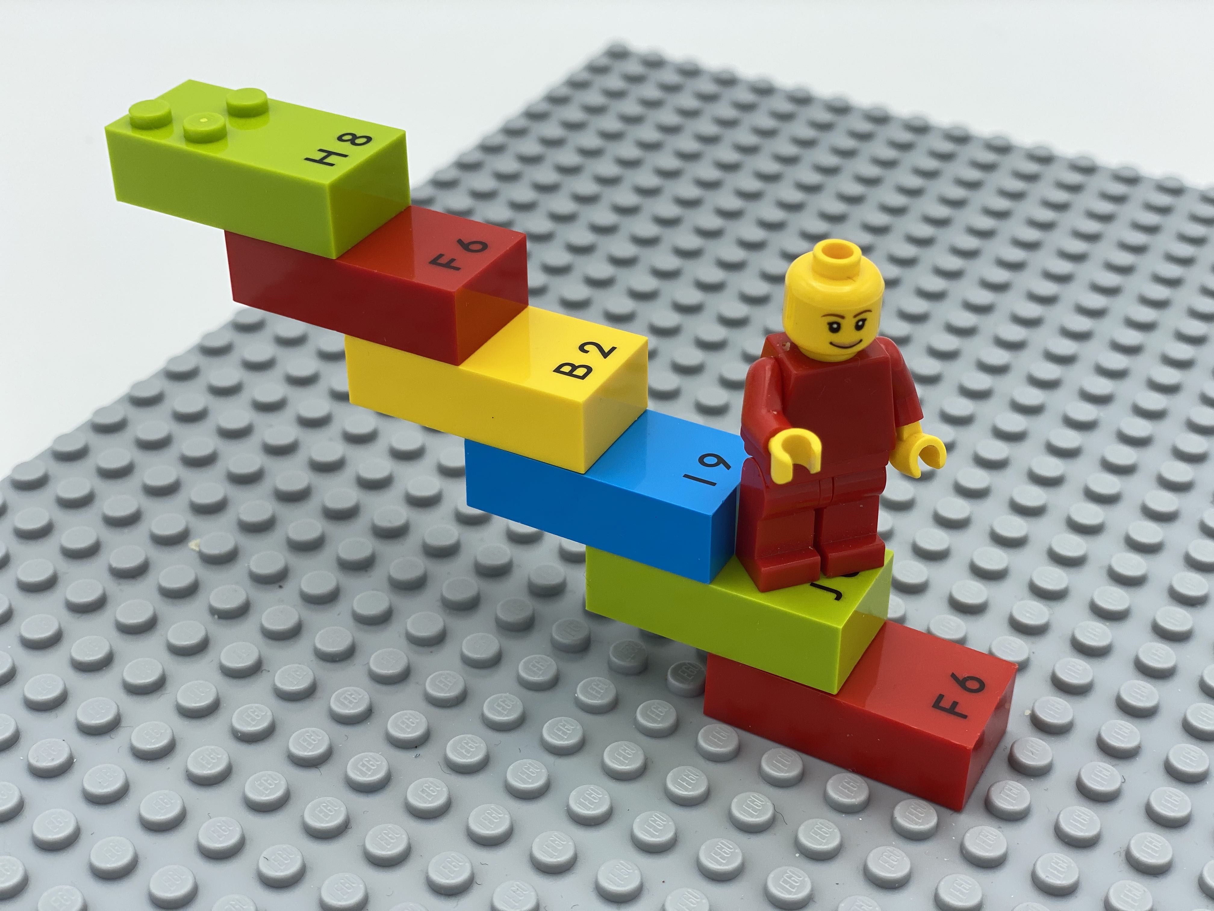 1 staircase made of bricks, with a LEGO mini figure on step 2.