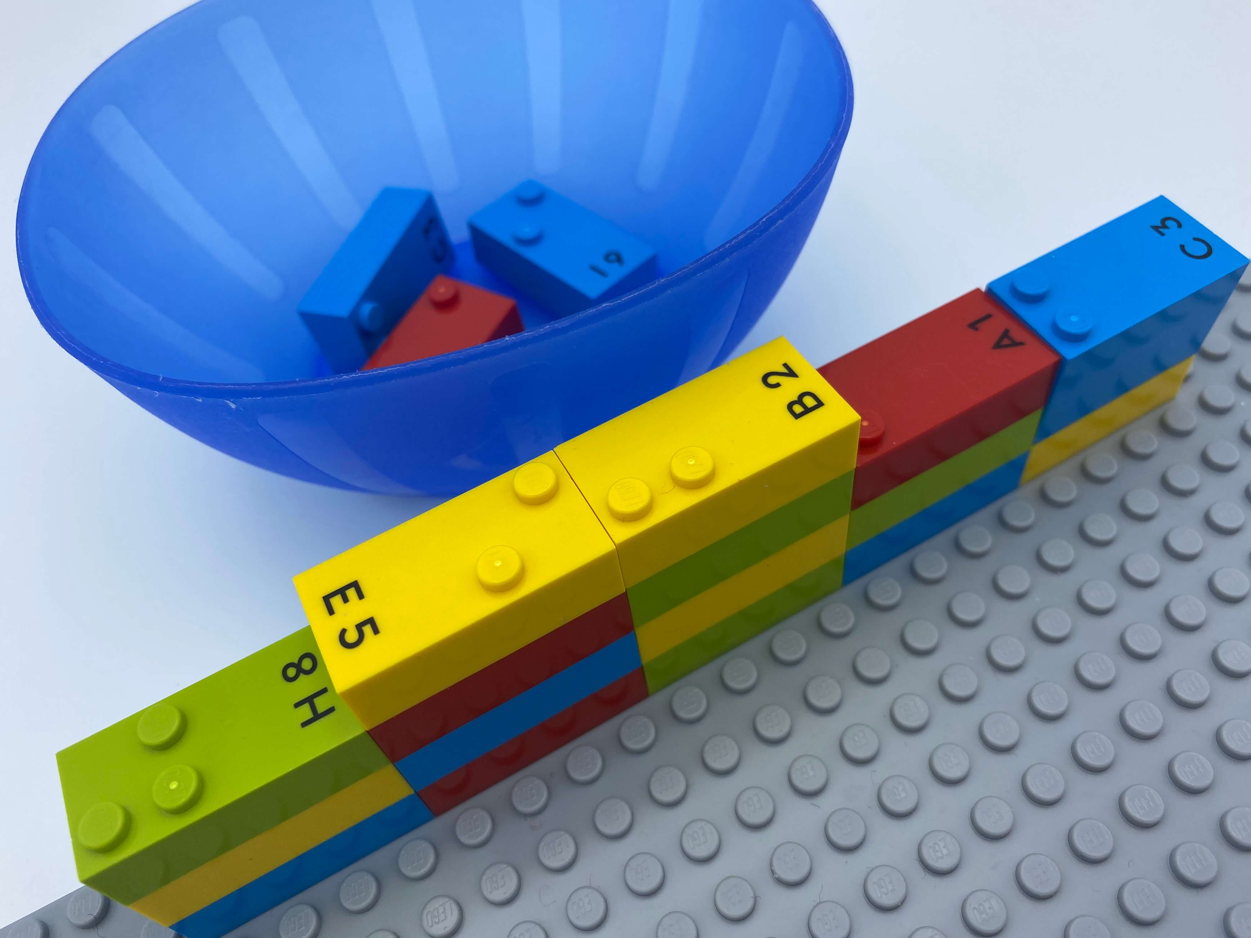 A wall of number bricks on the top of the base plate being demolished, a bowl with bricks. We can see number bricks 8, 5, 2, 1, 3.