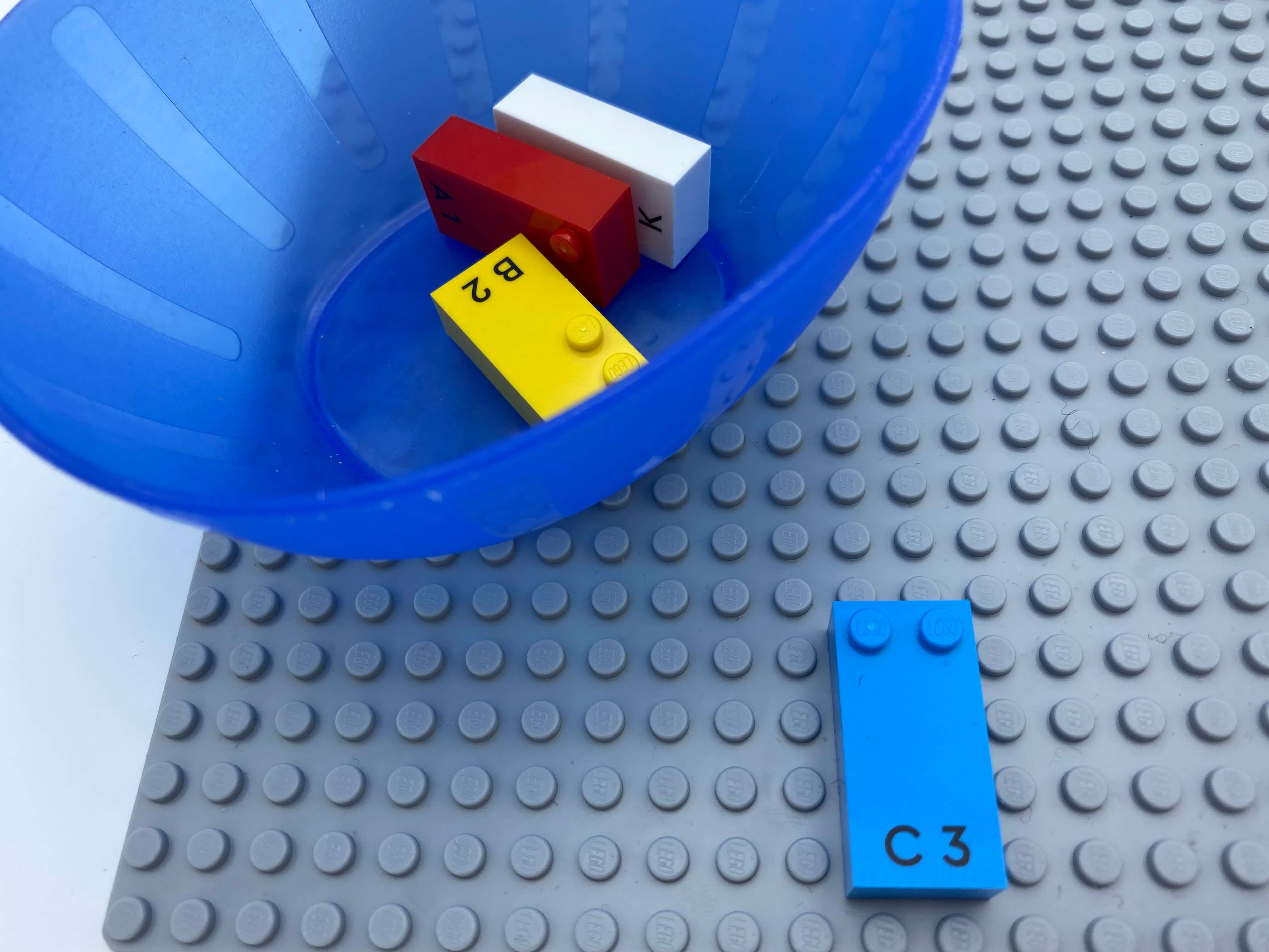 Letter brick C on the base plate, a bowl with letter bricks a, b, k.