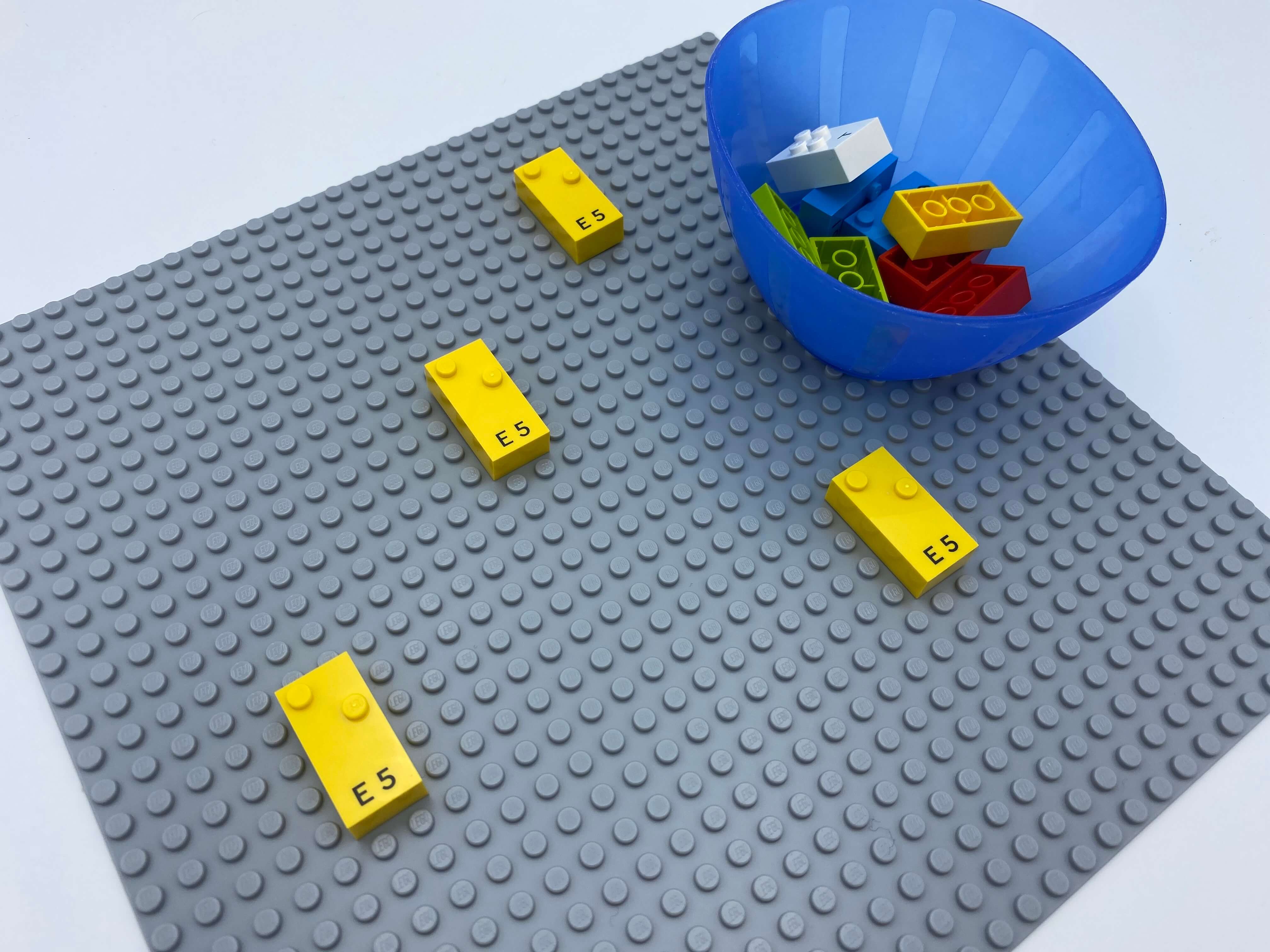 4 letter bricks spread over the base plate, one bowl with bricks.