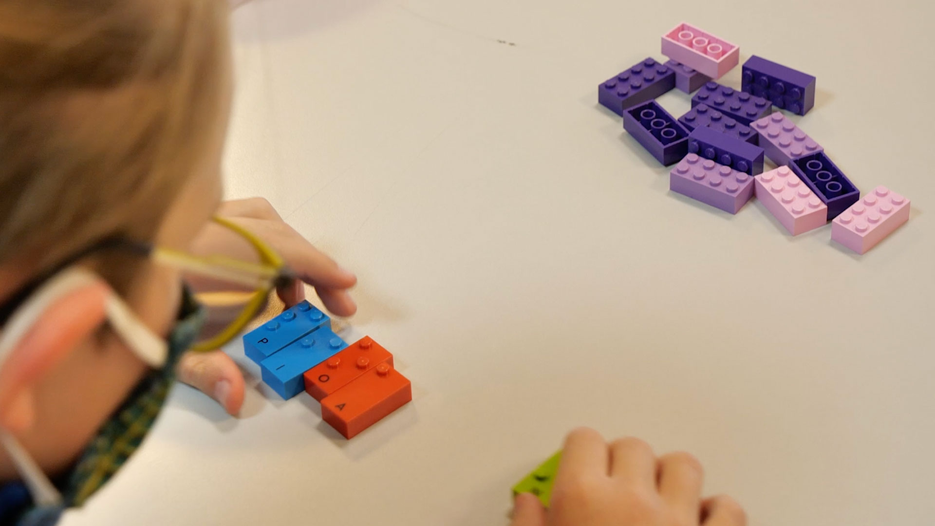 Child doing an activity with both classic and braille LEGO Bricks.