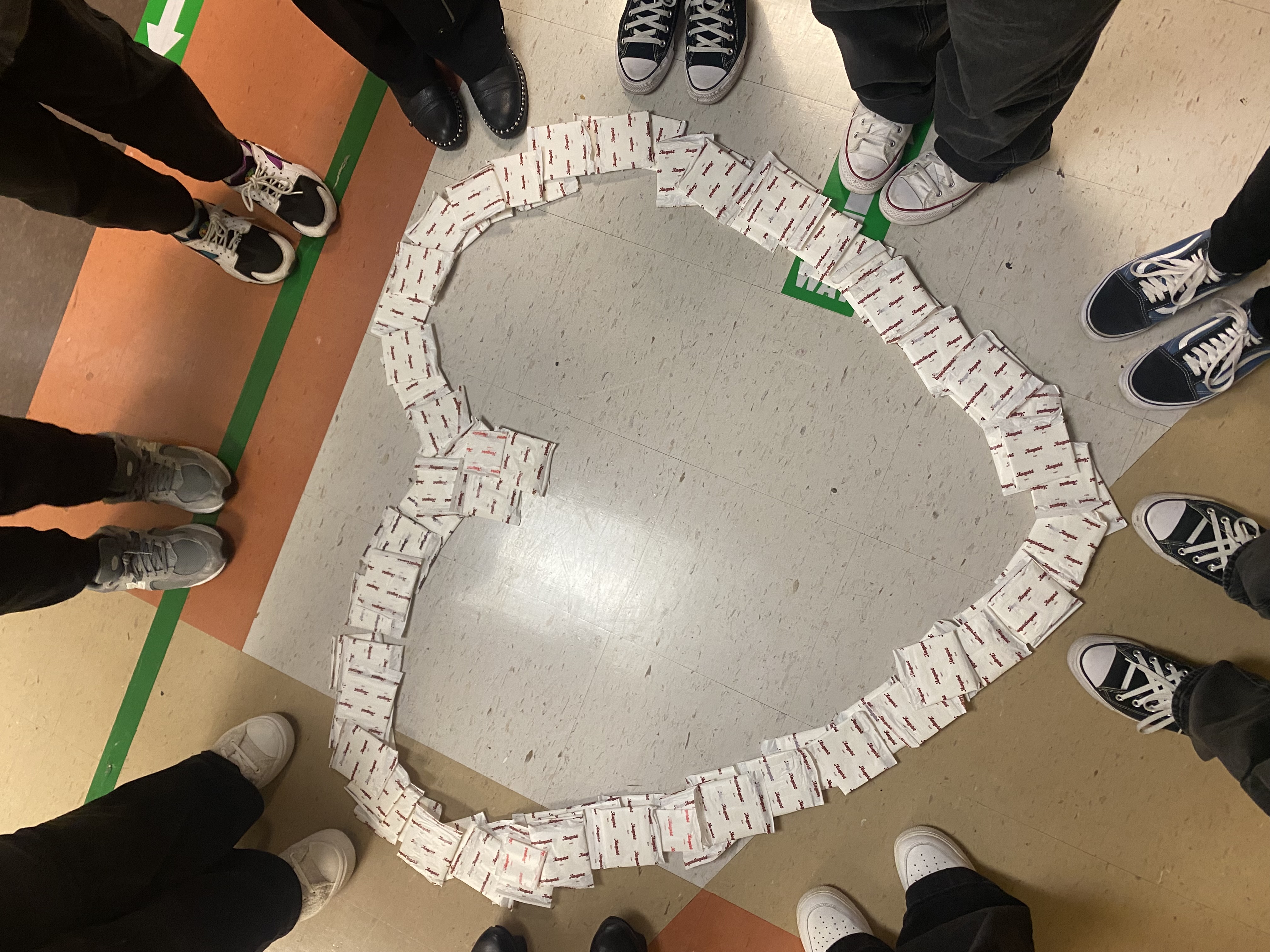 a group of people standing around a large mosaic