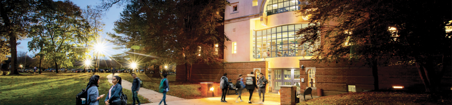 College students walking across NYIT campus at dusk highlighting brand awareness through Snapchat For Business advertising.