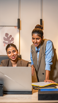 محترفات في مجال التقنية يتعاون حول جهاز حاسوب، يوضح كيف تدعم إعلانات سناب شات نمو العلامات التقنية.