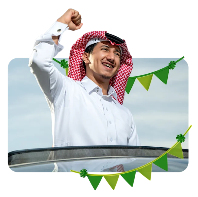 Man celebrating Saudi National Day with festive garland decorations in the foreground