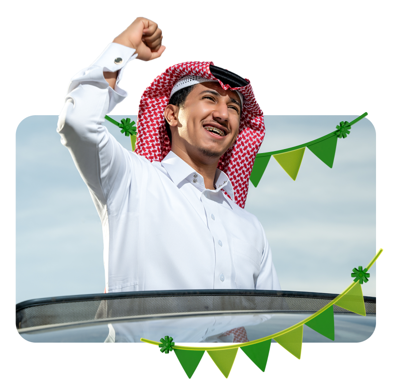 Man celebrating Saudi National Day with festive garland decorations in the foreground