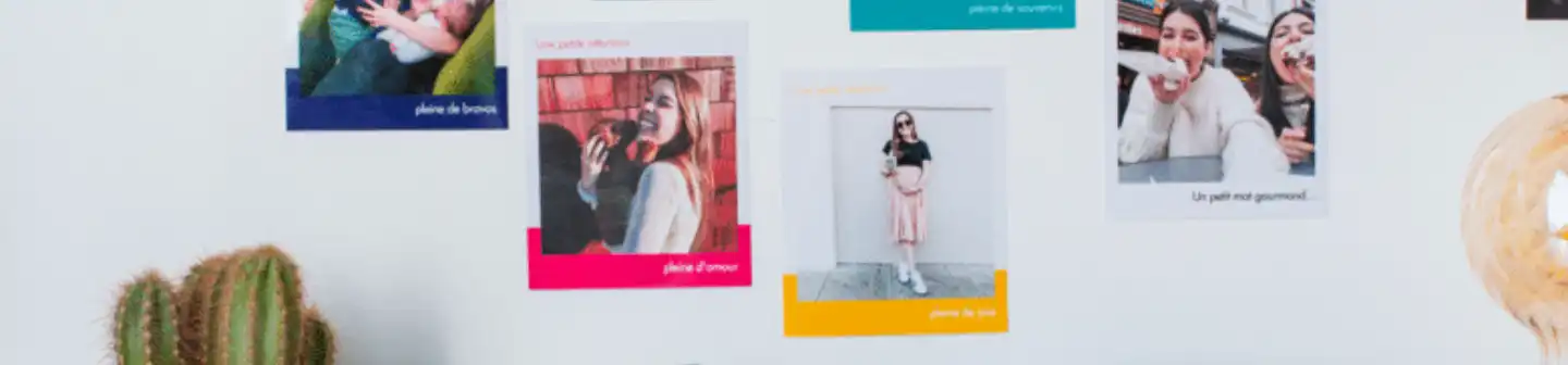 A wall decorated with colorful printed photos from Cheerz, showcasing personalized photo prints with captions for a creative display.